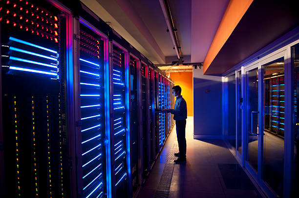 Modern interior of server room in datacenter. IT Engineer in Action Configuring Servers